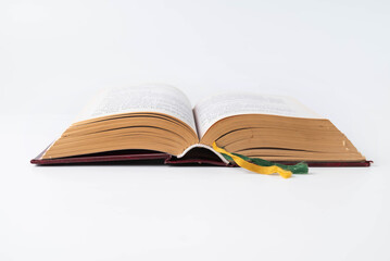 On a white background, an open old book with bookmarks. The concept of study, wisdom.