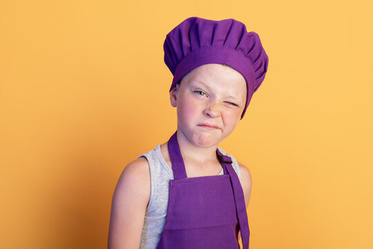 Funny child in cook outfit winking at camera
