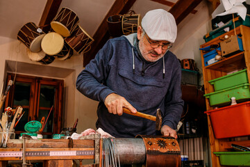 Artisan making drum shell in workshop
