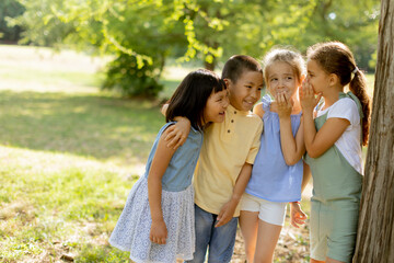 Obraz premium Group of asian and caucasian kids having fun in the park