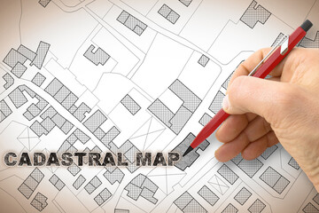 Hand writing the text -Cadastral map- on an imaginary cadastral map of territory with buildings, roads and land parcel - concept image with copy space