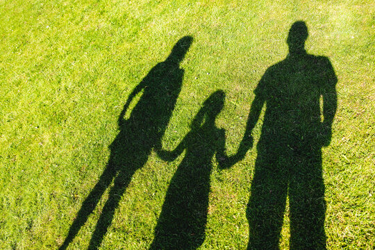 Shadow of family with mother father and daughter together at park