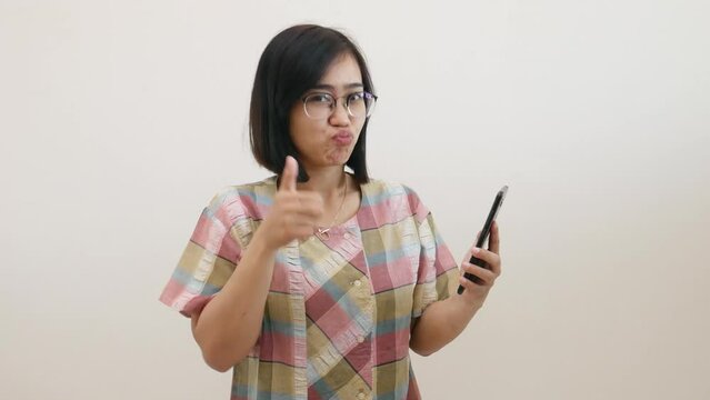 Asian woman standing while showing her cell phone with green screen