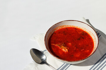 Red borsch red soup with meat in a plate with spoon. Space for text