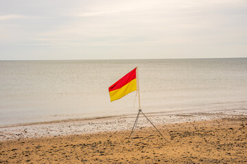 red and yellow danger warning flags on beach life saving  guards safety zone