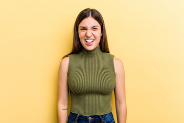 Young caucasian woman isolated on yellow background funny and friendly sticking out tongue.