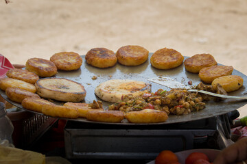 aloo tikki kulche chhole being prepared on tawa in roadside shop. famous traditional north indian vegetarian street food.