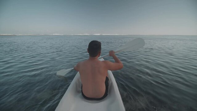 Indonesian Man Canoeing Paddling Canoe at Gunung Payung Beach, Bali, Indonesia Slow Motion