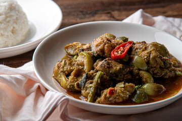 Stir fry spicy catfish on dark wooden background. Thaifood concept.