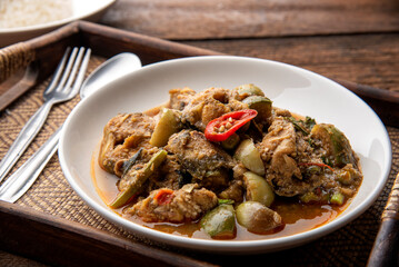 Stir fry spicy catfish on dark wooden background. thaifood concept.