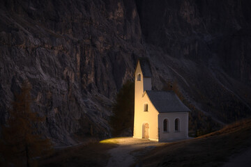 Incredible view on small iIlluminated chapel - Kapelle Ciapela on Gardena Pass, Italian Dolomites mountains. Dolomite Alps, Italy. Landscape photography - obrazy, fototapety, plakaty