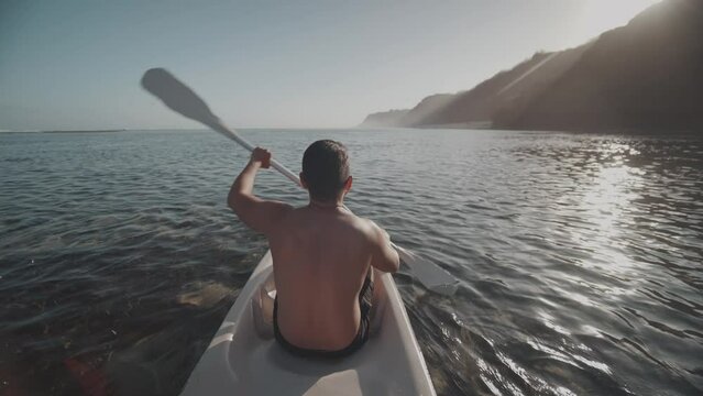 Indonesian Man Canoeing Paddling Canoe at Gunung Payung Beach, Bali, Indonesia Slow Motion