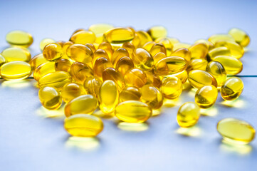 Yellow capsules on a light background. Medical preparations.
