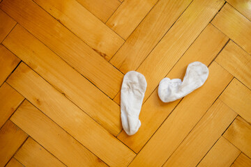 Dirty white socks on a wooden floor