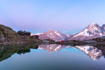 Colourful sunset on Lac Blanc lake in France Alps. Monte Bianco mountain range on background. Vallon de Berard Nature Preserve, Chamonix, Graian Alps. Landscape photography - obrazy, fototapety, plakaty