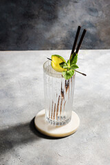 carbonated mineral water with lime and mint in the glass on gray background