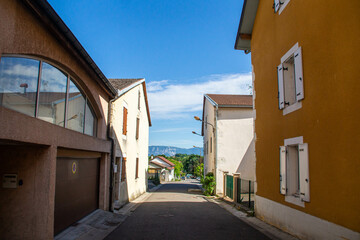 Fototapeta na wymiar Houses on narrow street Rue du Bordeau, Saint-Genis-Pouilly, France
