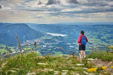 nice senior woman hiking at Mount Gruenten in the Allgaeu Alps with awesomw view over Iller valley...