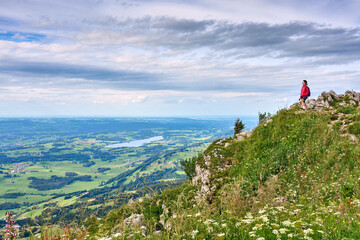 nice senior woman hiking at Mount Gruenten in the Allgaeu Alps with awesomw view over Iller valley...