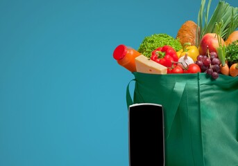 Grocery shopping app and grocery bag full of goods: shopping and home delivery concept