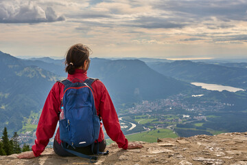 nice senior woman hiking at Mount Gruenten in the Allgaeu Alps with awesomw view over Iller valley...