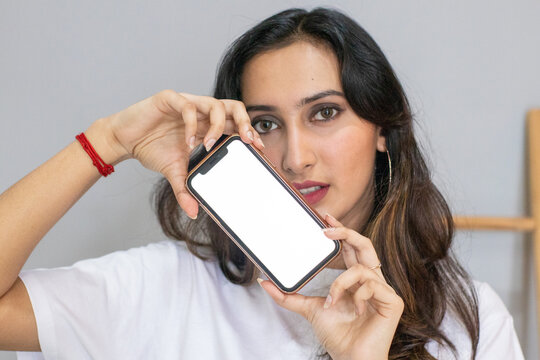 Mockup image of a woman holding a white blank screen smartphone