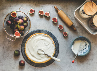 Figs tart preparation with fruits, bowls, cheesecake cream, wooden rolling pin and kitchen utensils...