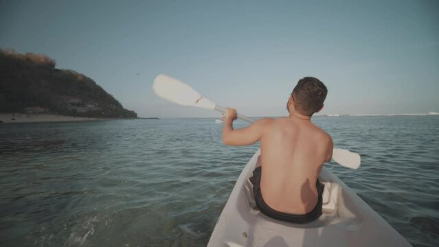 Indonesian Man Canoeing Paddling Canoe at Gunung Payung Beach, Bali, Indonesia Slow Motion