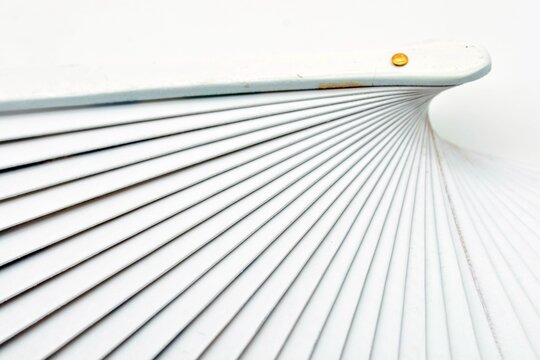 Detalle de un abanico de madera pintado de blanco