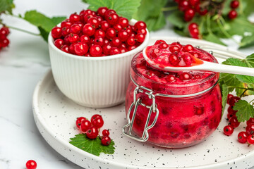 red currant jam with fresh berry. Canned berries on a light background. Food recipe background. Close up
