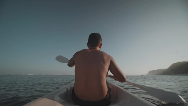 Indonesian Man Canoeing Paddling Canoe at Gunung Payung Beach, Bali, Indonesia Slow Motion