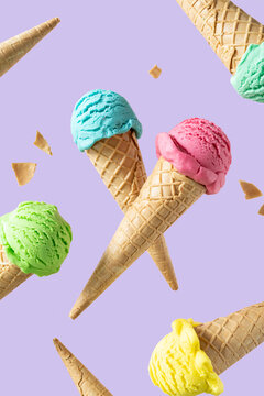Flying colorful ice cream scoops in cones, bright background. Levitation