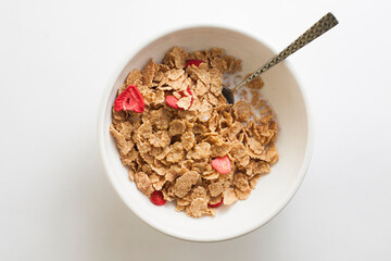 Sweet Wheat Flakes and Strawberries Cereal in a bowl with a spoon