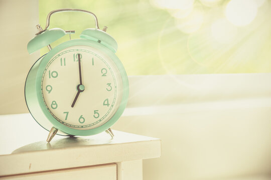 Circadian rhythms concept - alarm clock set on 7 am with sun rays