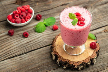 Yogurt smoothie with raspberries in glass on wooden table. weight loss concept. banner, menu, recipe place for text, top view