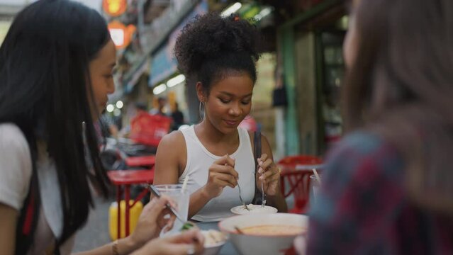 Group of Beautiful Young Ladies Travel at Local City. They Enjoy to Eat Local Food Together. Travel and Lifestyle Concept.