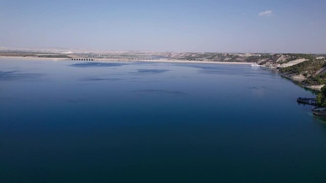 Aerial view of the Birecik dam and water reservoir on Euphrates river near the ruins of the ancient city of Zeugma. Border of Gaziantep and Sanliurfa provinces, Turkiye