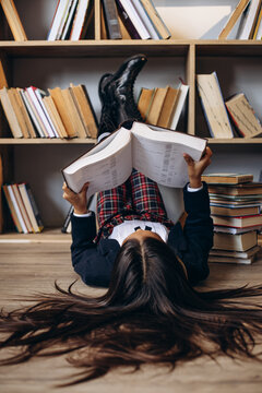 Pretty school girl reading books at the library