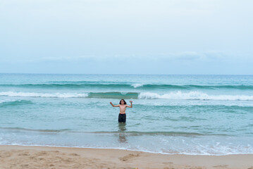 Extreme long shot of a teenager with long hair bathing in the Mediterranean Sea. There is copy space.