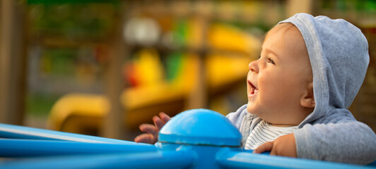 Little boy, baby. Children play and enjoy riding the carousel in the playground.