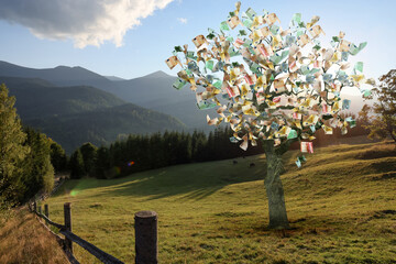 Money tree on pasture in mountains. Concept of financial growth and passive income - obrazy, fototapety, plakaty