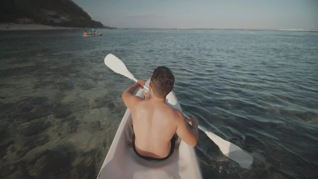 Indonesian Man Canoeing Paddling Canoe at Gunung Payung Beach, Bali, Indonesia Slow Motion