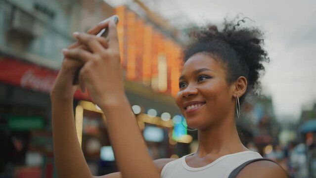 Portrait of beautiful young woman travel at city. She using smartphone camera to taking photo at city. Slow motion shot.