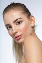 Closeup profile portrait of a young woman with natural makeup, looking at the camera, isolated...