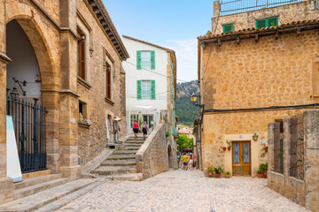 Fototapeta na wymiar A picturesque street of shops and cafes in the medieval village of Valldemossa, Spain, on the Mediterranean island of Mallorca.