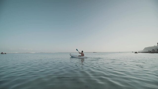 Indonesian Man Canoeing Paddling Canoe at Gunung Payung Beach, Bali, Indonesia Slow Motion
