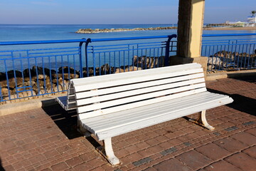 Fototapeta na wymiar Bench in a city park on the Mediterranean coast
