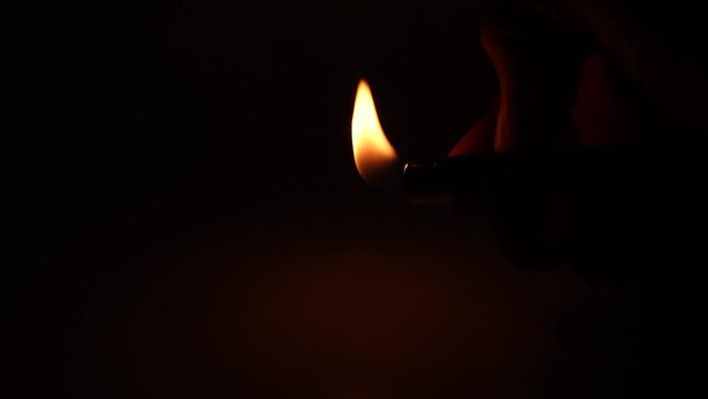 person lighting a lighter in the dark. Beware of fire.