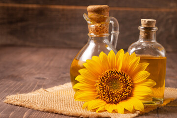 Closeup photo of sunflower oil with seeds on wooden background. Bio and organic product concept.