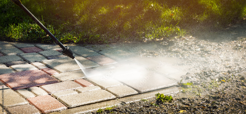 Wall mural dirty block pavement cleaning with high pressure washer. copy space